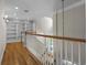 Hallway with wood floors, a white staircase, and a built-in bookshelf creates a stunning focal point at 675 Wedgewood Dr., Murrells Inlet, SC 29576