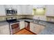 A well-lit kitchen featuring stainless steel appliances, granite countertops, and ample cabinet space at 70 Mingo Dr. # 3-E, Pawleys Island, SC 29585