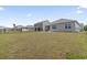 Large, grassy backyard with a black fence and views of neighboring homes at 7005 Grant St., Little River, SC 29566