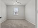 A carpeted bedroom includes a ceiling fan, window, and neutral colored walls, offering a comfortable space at 7005 Grant St., Little River, SC 29566