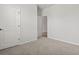 A carpeted bedroom offers a door and a view into the next room at 7005 Grant St., Little River, SC 29566