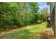 Lush backyard with a grassy area and mature trees, creating a private outdoor space at 77 Weatherboard Ct., Pawleys Island, SC 29585