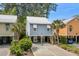 Charming raised beach house with vibrant blue siding, white trim, palm trees, and covered parking at 77 Weatherboard Ct., Pawleys Island, SC 29585