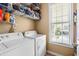 Functional laundry room with a white washer, dryer and shelving for storage at 77 Weatherboard Ct., Pawleys Island, SC 29585