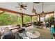 Spacious screened porch with ceiling fans, wicker furniture, and outdoor dining area at 77 Weatherboard Ct., Pawleys Island, SC 29585