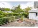 Exterior shot of backyard with a patio, white railings, lush greenery, and neighboring homes at 835 South Marlin Circle, Murrells Inlet, SC 29576