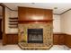 Close up of the cozy stone fireplace with wood mantle and built-in cabinets at 835 South Marlin Circle, Murrells Inlet, SC 29576