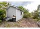 Exterior view of the backyard shed with gray siding and a small brick patio surrounded by greenery at 835 South Marlin Circle, Murrells Inlet, SC 29576