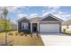 Charming single-story home features a two-car garage, gray accents, and inviting front yard landscaping at 882 Farmers Passage Loop, Loris, SC 29569