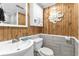Bathroom with wood wall, vanity, toilet, and stone tile at 1012 N Waccamaw Dr. # 507, Murrells Inlet, SC 29576