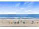 Expansive beach view with blue water and sunbathers at 1012 N Waccamaw Dr. # 507, Murrells Inlet, SC 29576