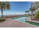 An outdoor pool overlooks the beach, surrounded by lush landscaping and seating at 1012 N Waccamaw Dr. # 507, Murrells Inlet, SC 29576