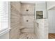 Modern walk-in shower showcasing neutral tile, mosaic accents, a built-in seat, and a glass enclosure at 1151 N Blackmoor Dr., Murrells Inlet, SC 29576