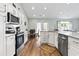 Bright kitchen boasts white cabinetry, stainless steel appliances, and hardwood flooring at 121 Ashworth Dr., Little River, SC 29566