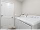 Bright laundry room boasts a white washer and dryer and a convenient adjacent closet at 121 Ashworth Dr., Little River, SC 29566