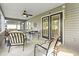 Inviting screened porch featuring comfortable seating, ceiling fan and a lovely outdoor dining area at 121 Ashworth Dr., Little River, SC 29566