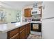 Compact kitchen features wooden cabinets, white countertops, and beach-themed decor at 1500 Cenith Dr. # B402, North Myrtle Beach, SC 29582