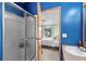 Bathroom with shower and vanity with blue walls and view to bedroom at 168 Saint Christopher Circle, Pawleys Island, SC 29585