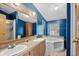 Blue bathroom featuring a soaking tub and double sink vanity at 168 Saint Christopher Circle, Pawleys Island, SC 29585