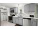 Updated kitchen with gray cabinets, stainless steel appliances, and neutral backsplash at 168 Saint Christopher Circle, Pawleys Island, SC 29585