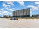 Exterior view of a condo building from the beach with sand and beach accessories visible at 1709 S Ocean Blvd. # 608, North Myrtle Beach, SC 29582