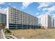 Exterior view of a tall condo building with multiple balconies and parking garage at 1709 S Ocean Blvd. # 608, North Myrtle Beach, SC 29582