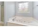 Bathroom featuring a soaking tub with jets and a decorative glass window at 197 Northside Dr., Little River, SC 29566