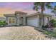Charming home with a tile roof, paver driveway, and lush landscaping including mature palm tree at 197 Northside Dr., Little River, SC 29566