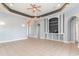 Bright, open living room featuring stylish built-ins, tray ceiling, and tile flooring at 197 Northside Dr., Little River, SC 29566