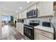 Modern kitchen with stainless steel appliances, wood-look floors, and a view of the open living area and ocean view at 200 76Th Ave. N # 1009, Myrtle Beach, SC 29572