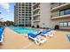 A condo complex pool is surrounded by lounge chairs and palm trees, offering a relaxing outdoor experience at 200 76Th Ave. N # 1009, Myrtle Beach, SC 29572