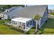 Aerial view showcasing the patio, a dining area, lounge seating, mature landscaping, and lush green lawn at 2005 Tiller Ct., Myrtle Beach, SC 29579