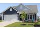 Charming home featuring a two-car garage and a cozy front porch with seating and manicured landscaping at 2005 Tiller Ct., Myrtle Beach, SC 29579