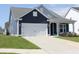Exterior showcasing the side of a charming home with a two-car garage and manicured lawn at 2005 Tiller Ct., Myrtle Beach, SC 29579