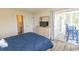 Bright bedroom with balcony access, comfortable bedding, and a dresser with TV at 201 Landing Rd. # D, North Myrtle Beach, SC 29582