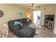 Comfortable living room has a large sectional sofa, area rug, ceiling fan, and balcony access at 201 Landing Rd. # D, North Myrtle Beach, SC 29582