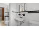 White tiled bathroom featuring a toilet, sink, mirror, and black trim, providing a clean and classic look at 2192 Highway 308, Galivants Ferry, SC 29544
