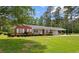 Beautiful brick home with white-trimmed windows, landscaped shrubs, and a spacious green lawn at 2192 Highway 308, Galivants Ferry, SC 29544