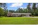 Picture of cozy brick home on a lush green lawn, shaded by mature trees and a bright blue sky at 2192 Highway 308, Galivants Ferry, SC 29544