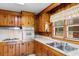 A kitchen featuring wood-paneled walls, stainless steel appliances, and a window with curtains at 2192 Highway 308, Galivants Ferry, SC 29544
