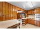 A kitchen with wooden paneling, a small dining area, and an open doorway leading to another room at 2192 Highway 308, Galivants Ferry, SC 29544