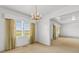 Open-concept living area with chandelier, carpet, and window with yellow drapes at 2192 Highway 308, Galivants Ferry, SC 29544