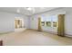 Open-concept living area with carpet, multiple windows with drapes, and interior door at 2192 Highway 308, Galivants Ferry, SC 29544
