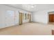 Open-concept living area with carpet, multiple windows with drapes, and interior door at 2192 Highway 308, Galivants Ferry, SC 29544