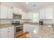 Well-lit kitchen featuring white cabinets, granite countertops and stainless steel appliances with a window view at 247 Rolling Oak Dr., Georgetown, SC 29440