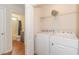 Bright laundry room features wooden floor, newer appliances, and access to bathroom at 247 Rolling Oak Dr., Georgetown, SC 29440