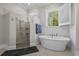 Beautiful bathroom featuring a soaking tub, glass-enclosed shower, white subway tile, and a large window at 2615 Painted Trillium Ct., Myrtle Beach, SC 29579