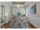 Cozy dining room featuring wood floors, bright windows with shutters, stylish chandelier, and wainscotting at 2615 Painted Trillium Ct., Myrtle Beach, SC 29579