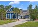 Charming blue two-story home with a well-manicured front yard, palm trees, and welcoming curb appeal at 2615 Painted Trillium Ct., Myrtle Beach, SC 29579