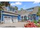 Front exterior of a charming blue house with a two-car garage, flower beds, and a welcoming porch at 2615 Painted Trillium Ct., Myrtle Beach, SC 29579